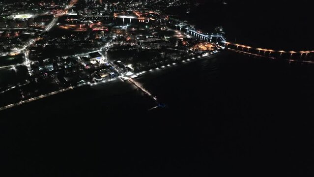 An enchanting drone film showcases Kołobrzeg's lighthouse and winter-night pier, blending coastal beauty with a serene ambiance and captivating nocturnal lights. Kolobrzeg, Poland.