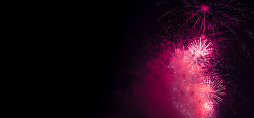 Holiday fireworks backgrounds with sparks, colored and bright light on black night sky, pyrotechnics. Amazing colorful fireworks at celebration, show. Holidays background concept. Copy ad text space
