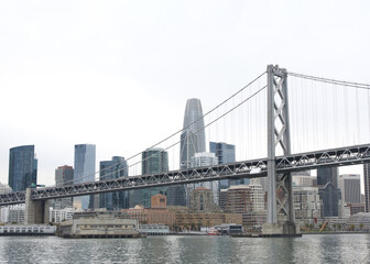 San Francisco city financial district with Bay Bridge in foreground. The Bay Bridge is part of Interstate 80 and a direct road between San Francisco and Oakland.