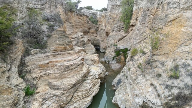 Ca&ntilde;&oacute;n de las lajas, un paisaje des&eacute;rtico en San Luis Potos&iacute;, M&eacute;xico. En medio del desierto, la arena blanca y la sequ&iacute;a hay un arrollo peque&ntilde;o al que rodea algunos &aacute;rboles. Textura en las rocas