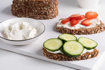 Rye bread with cream cheese and cucumbers, strawberry.