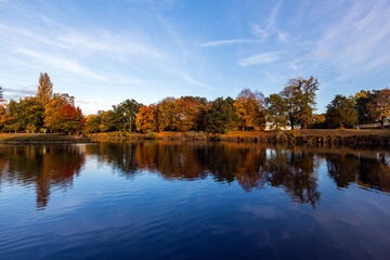 Autumn landscape with colorful trees and lake in the city park.