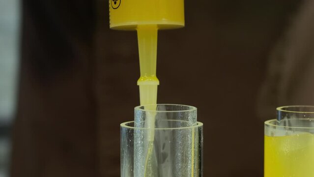 Stuffing of glass molds with flavored combination of juice and spices. Gelatin makes liquid solidify into perfectly cylinder shape