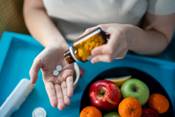 Female hands taking medicine from pill bottle. Healthcare, medicine, treatment, therapy concept.