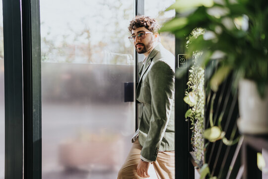 Good looking employee arriving at work. He is entering the office.