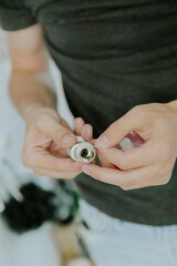 A young man wraps tow around the nut of a bathroom faucet.