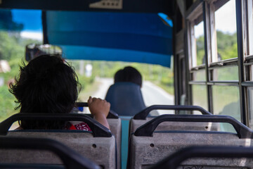 Passenger view from inside a bus looking out onto the road ahead