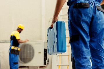 Electrician arriving on location to help wireman fix system electrical issues caused by faulty wiring or defective capacitor requiring professional intervention to diagnose and repair