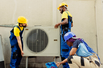 Knowleadgeable engineering team installing new outdoor air conditioner for home owner after...