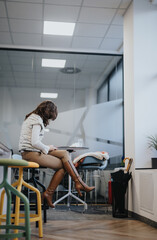 Stylish woman resting at modern kitchen at work.