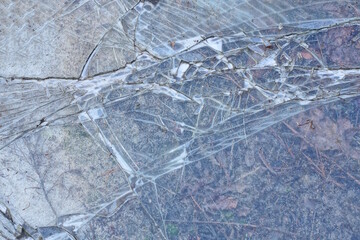 gray texture of a broken piece of glass with cracks