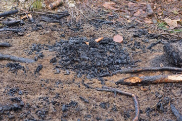 an extinct fire made of black ash and ash on the brown ground on the street