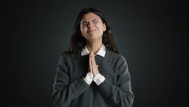The beautiful young woman, folding her hands in front of herself, pleads for help. High quality 4k footage