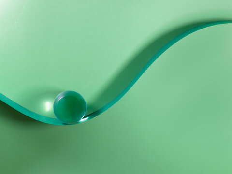 Glass sphere on a sigmoid curve against a green background