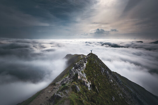 Distant rear view of a hiker standing on top of Errigal mountain, County Donegal, Ireland