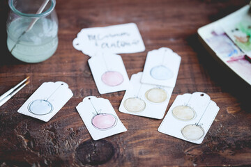 Close-up of Homemade Watercolour paint Christmas gift Tags on a wooden table