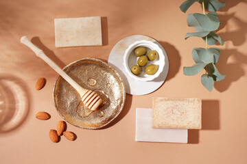 Composition with soap bars, natural ingredients and eucalyptus branch on color background