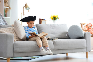 Cute little pirate with adventure book at home