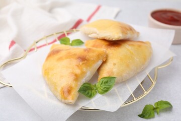 Delicious samosas and basil on white table