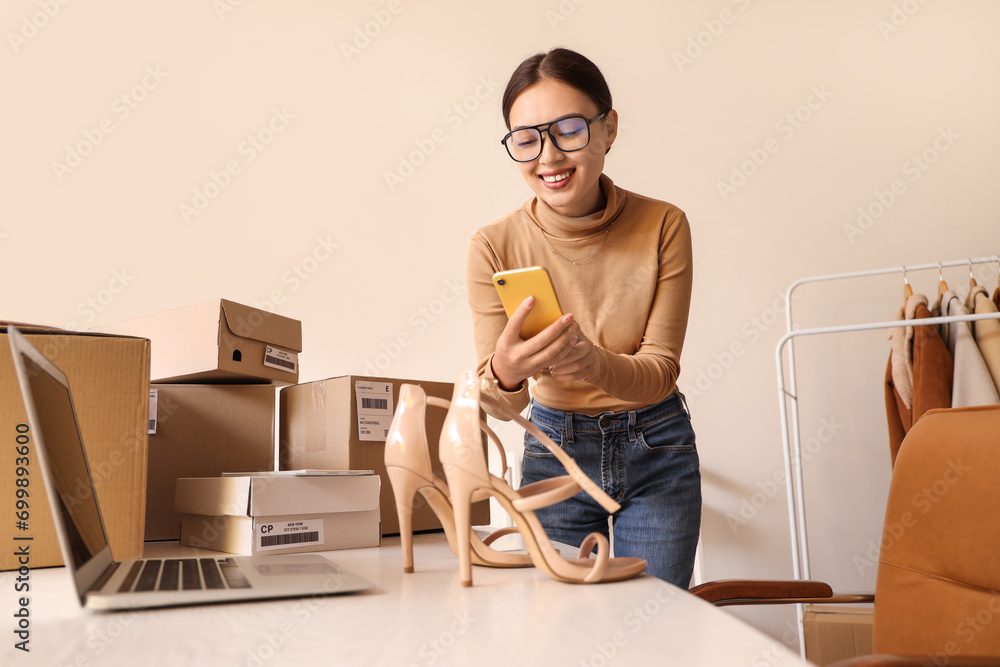 Poster female asian seller taking picture of heels in warehouse store