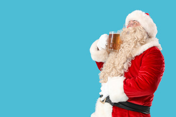 Santa Claus with mug of beer on blue background