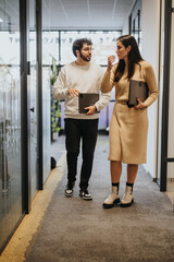 A group of coworkers walking and discussing ideas in a modern office, focusing on teamwork and profitability.