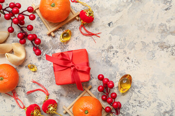 Gift box with mandarins, fortune cookies and Chinese symbols on grunge background. New Year celebration