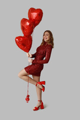 Beautiful young woman with heart-shaped balloons on light background. Valentine's Day celebration