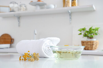 Fototapeta na wymiar Steam inhalation with herbs and towel on table in kitchen, closeup
