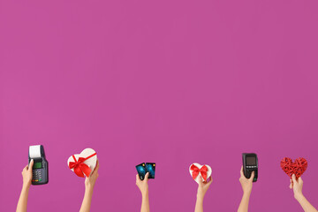 Women with payment terminals, credit cards and gifts on purple background. Valentine's Day...