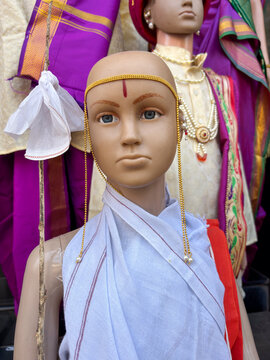 A dummy statue displayed showing a kid wearing traditional dress on occassion known as munj a threading ceremony