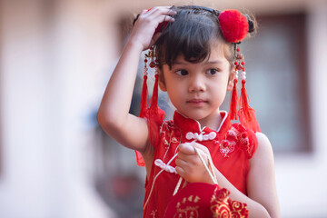 Cute little girl wearing a red Chinese traditional dress during the Chinese New Year festival