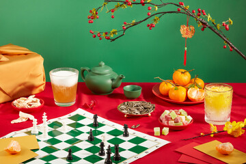 A seahorse chess board, a glass of soft drink, a plate of tangerines, a plate of sunflower seeds, a plate of colorful gummy candy, a tea set, etc. are displayed on a red and green background.