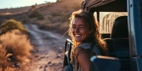 Portrait of happy young woman sitting in a car window at a sunny day