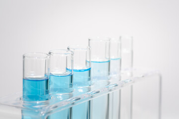 Chemistry laboratory tube glass, science laboratory research and development concept, flask, beaker, and test tubes with dropping blue liquid water sample test, scientific test tubes equipment.