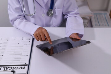Fototapeta premium Close up of the ears of a professional female doctor in uniform taking notes in a notebook Medical therapist filling out medical documents. Clipboard. Patient form. Illness history, prescription
