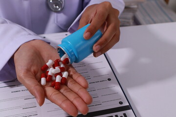 Close up of the ears of a professional female doctor in uniform taking notes in a notebook Medical therapist filling out medical documents. Clipboard. Patient form. Illness history, prescription