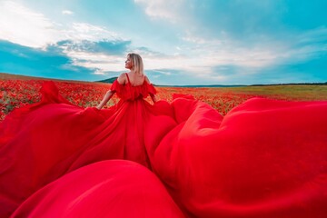 Woman poppy field red dress. Happy woman in a long red dress in a beautiful large poppy field....