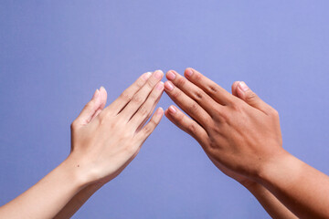 Close up of Muslim couple hands showing congratulate gesture during Eid Mubarak on gray background