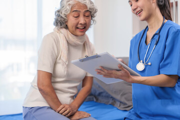 Health check concept, Elderly Asian woman with grey hair, sitting and talking to young Asian nurse by appointment, sitting on medical bed. - obrazy, fototapety, plakaty