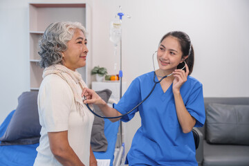 Health check concept, Elderly Asian woman with grey hair, sitting and talking to young Asian nurse by appointment, sitting on medical bed.
