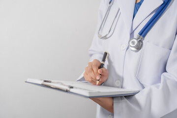 Close-up of a doctor hand holding pen and writing on medical form that attached to a clipboard. - Powered by Adobe