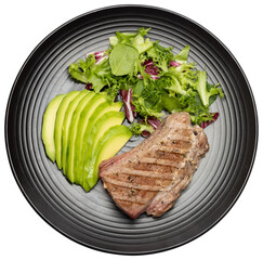 grilled cooked piece of tuna fillet with sliced avocado and salad on black ceramic plate