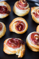 Obraz na płótnie Canvas Puff pastry swirls. Close-up of puff pastry with prosciutto. 