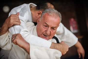 Close-up portrait of judo sensei master instructor in traditional gi kimono demonstrate judo...