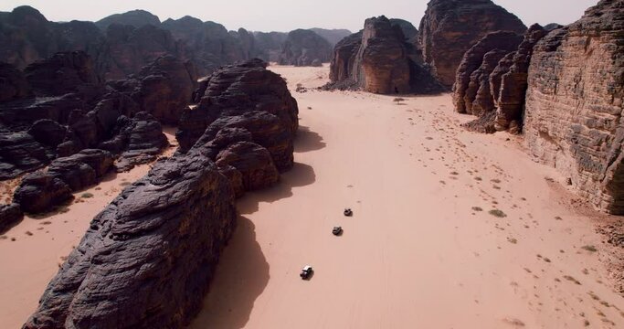 Four-by-four SUV's Driving Through The Sahara Desert In Tassili n'Ajjer National Park, Djanet, Algeria. - aerial shot