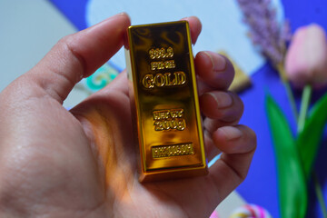 Gold bar weighing 250 grams in hand. Symbol of wealth