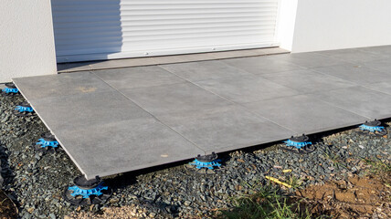Exterior pavement tiles floor installation on modern house terrace with adjustable paving terrace...