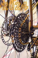 Bike speed changing assembly. Rear wheel with 2024 Happy New Year made from golden chain links