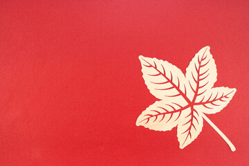 Tropical leaf made from paper cutting on red background.